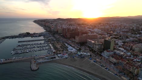 aerial dolly over fuengirola hills harbor at sunset