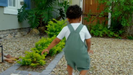 rear view of cute little black baby playing in back yard of their home 4k