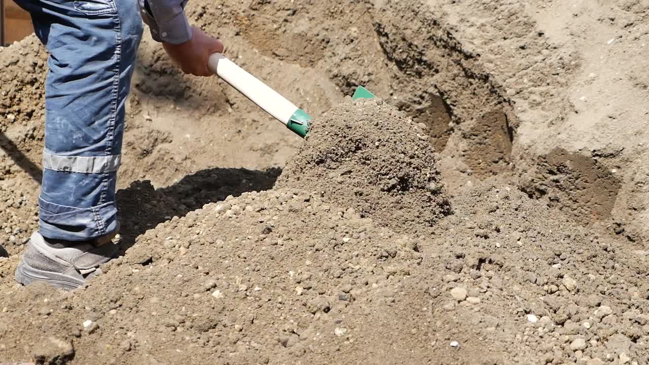 Construction worker using a shovel to move dirt