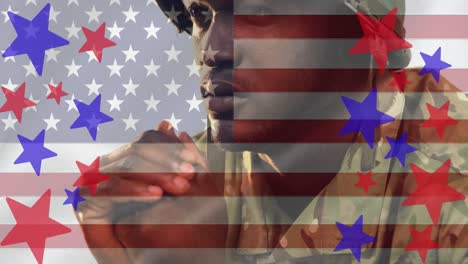Composition-of-red-and-blue-stars,-over-thoughtful-male-soldier-and-american-flag