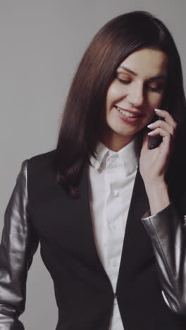 woman talking on the phone. young stylish woman talking on phone and posing in the studio