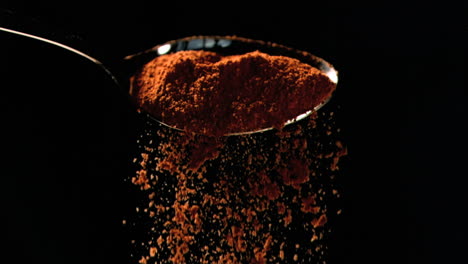 orange powder falling in super slow motion out of a spoon