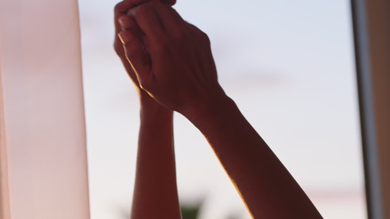 mujer feliz con los brazos levantados disfrutando del amanecer temprano en casa sintiendo una libertad pacífica relajándose en vacaciones mirando la hermosa vista del océano