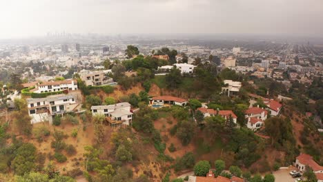 Plano-General-Aéreo-De-Casas-En-Las-Colinas-De-Hollywood-Con-Los-Angeles-Nebulosos-En-El-Fondo