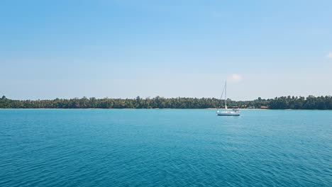 vista de la puesta de sol sobre el tranquilo mar de koh chang con silueta de palmeras, aguas tranquilas y cielo vibrante