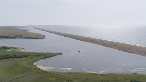 Luftverfolgung-Von-Rechts-Nach-Links-Entlang-Des-Chesil-Beach-Und-Der-Flottenlagune,-Die-Den-Schuss-Auf-Das-Meer-Und-Den-Entgegenkommenden-Sonnenschein-Dreht