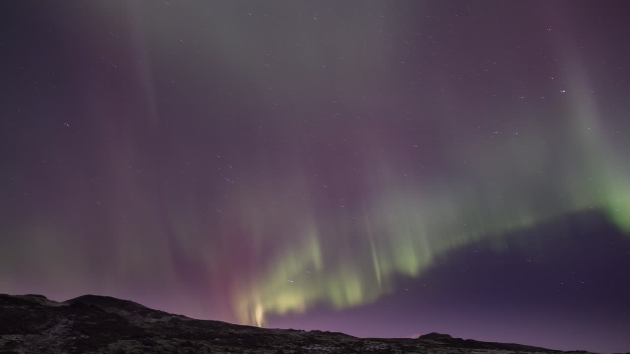 bucle sin fisuras de luces del norte brillan sobre las montañas en el cielo estrellado
