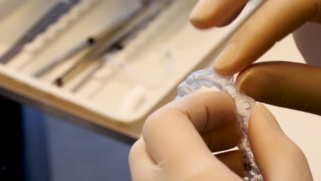 Tight-close-up-of-a-dentist-checking-an-invisalign-retainer