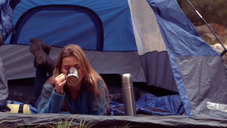 woman enjoying hot drink in her tent