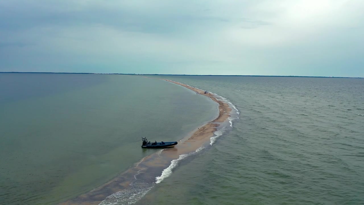 RIB-motorbåd ankret op på Rybitwia Mielizna sandbanke. Luftfoto viser fartøj fortøjet i lavt turkist vand i Puck Bugt på en sommerdag