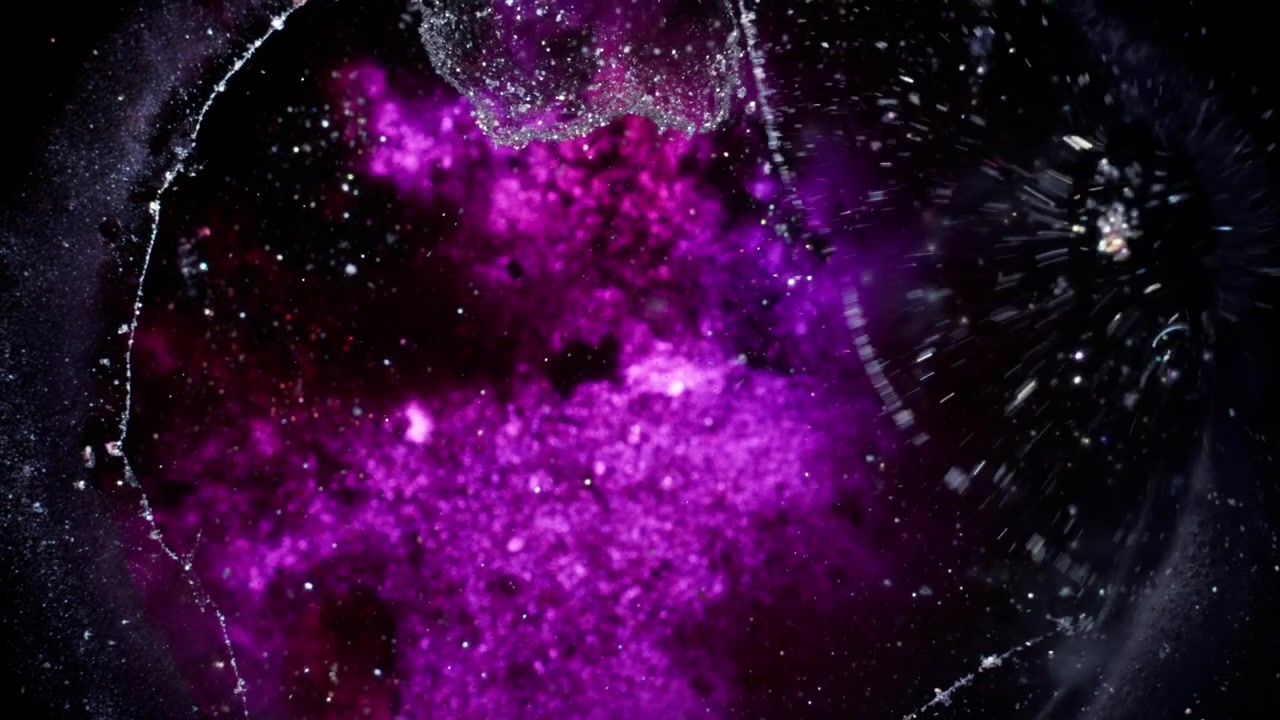 Tiefes Lila und Magenta Alkohol-Tinte mit funkelnden Partikeln, die sich in einer dunklen Leere entwickeln. Makroansicht einer kosmisch inspirierten Flüssigkeit in einer filmischen Studio-Umgebung