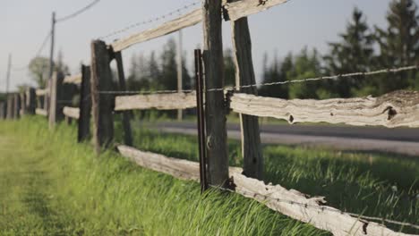 Rack-focus-along-a-wooden-fence-with-barbed-wire-on-it