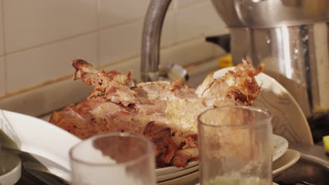 scraps, bones and goose or chiken skeleton on dirty dishes and mess after a party at home close-up. christmas table after the holiday celebrating. cleaning the house after dinner with friends and family. home cleaning services