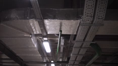 underground facility ceiling with pipes, ducts and electrical conduits