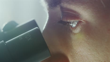 close-up of female lab technician working with microscope