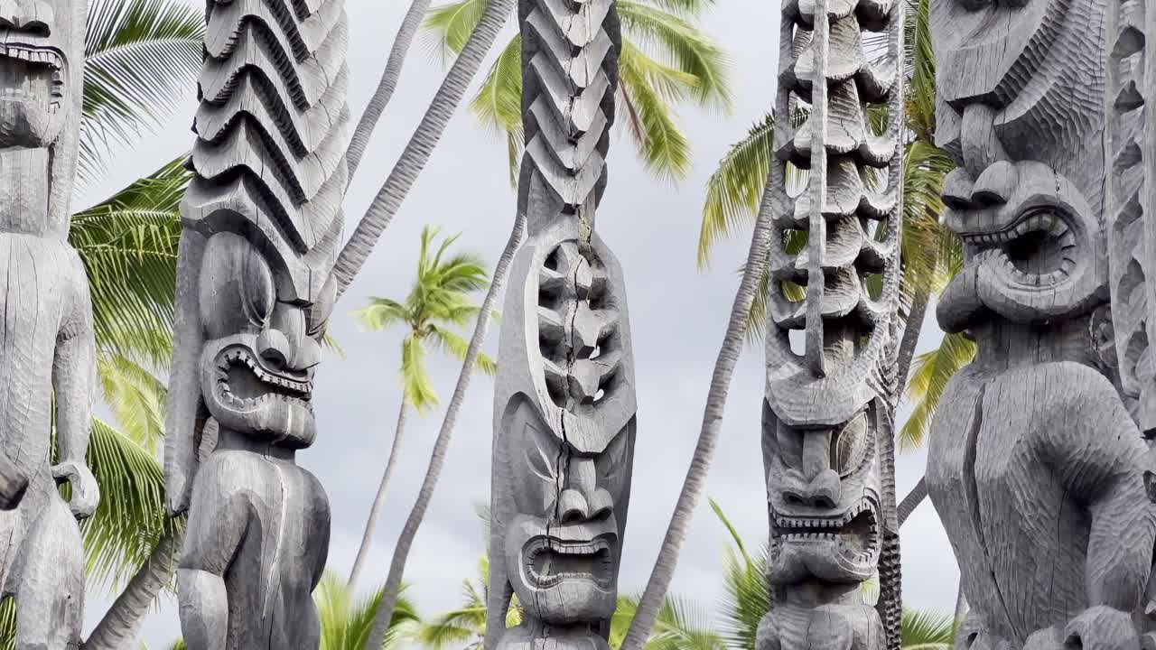 Cinematic close-up booming down shot of tiki statues at Pu'uhonua O Honaunau National Historical Park on the Big Island of Hawai'i