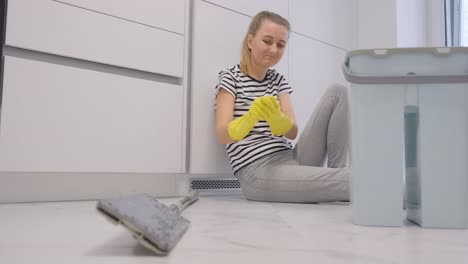a tired housewife resting for a few minutes after a long day of cleaning the apartment a tired housewife resting for a few minutes after a long day of cleaning the apartment she relaxes for a moment her hair is in a bun and she is wearing comfortable clothes enjoying peace and quiet at home