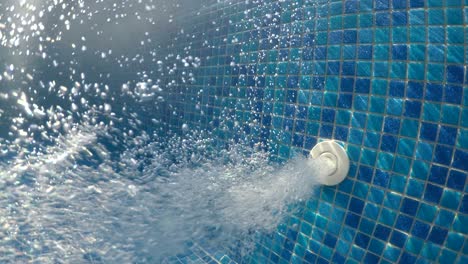 salida montada en la pared que hace estallar burbujas de aire en una piscina de spa térmica
