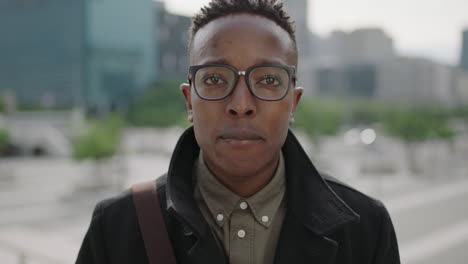 close up portrait of young happy african american man student smiling cheerful at camera wearing glasses in city