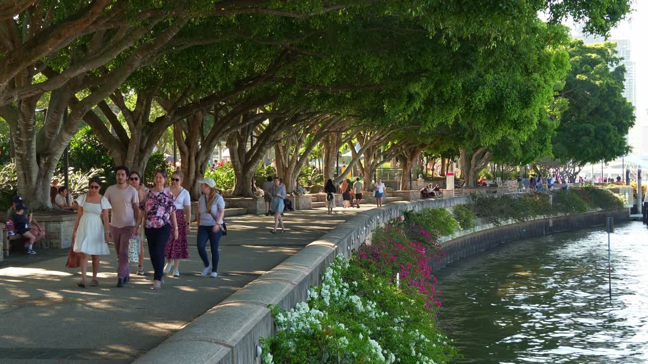 Time-lapse shot capturing people strolling along the riverside Clem Jones Promenade in South bank on the weekend, a tranquil oasis of Brisbane lifestyle recreational precinct by the river.