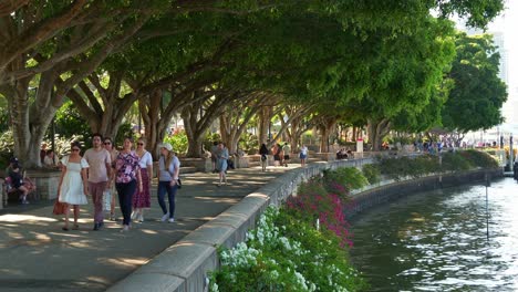 time-lapse shot capturing people strolling along the riverside clem jones promenade in south bank on the weekend, a tranquil oasis of brisbane lifestyle recreational precinct by the river.