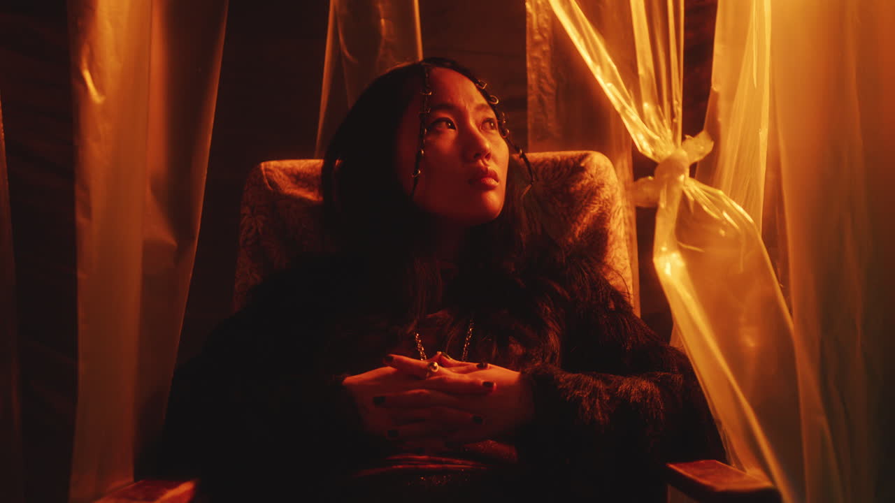Young Beautiful Asian Model Posing in Armchair in Studio with Neon Light
