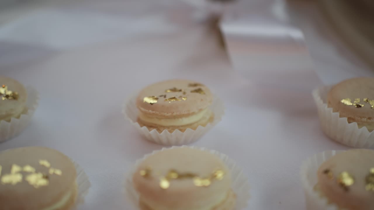 macarons with golden details elegantly displayed on a table, dolly top down