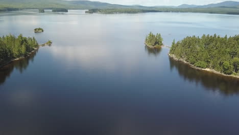 gorgeous aerial shot of a speed boat cruising down rangeley lake, maine