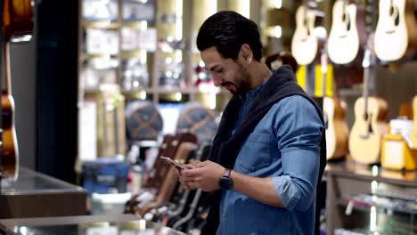 young handsome man using smartphone and payment by smartphone contactless