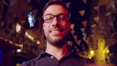 hombre sonriendo en un entorno nocturno festivo