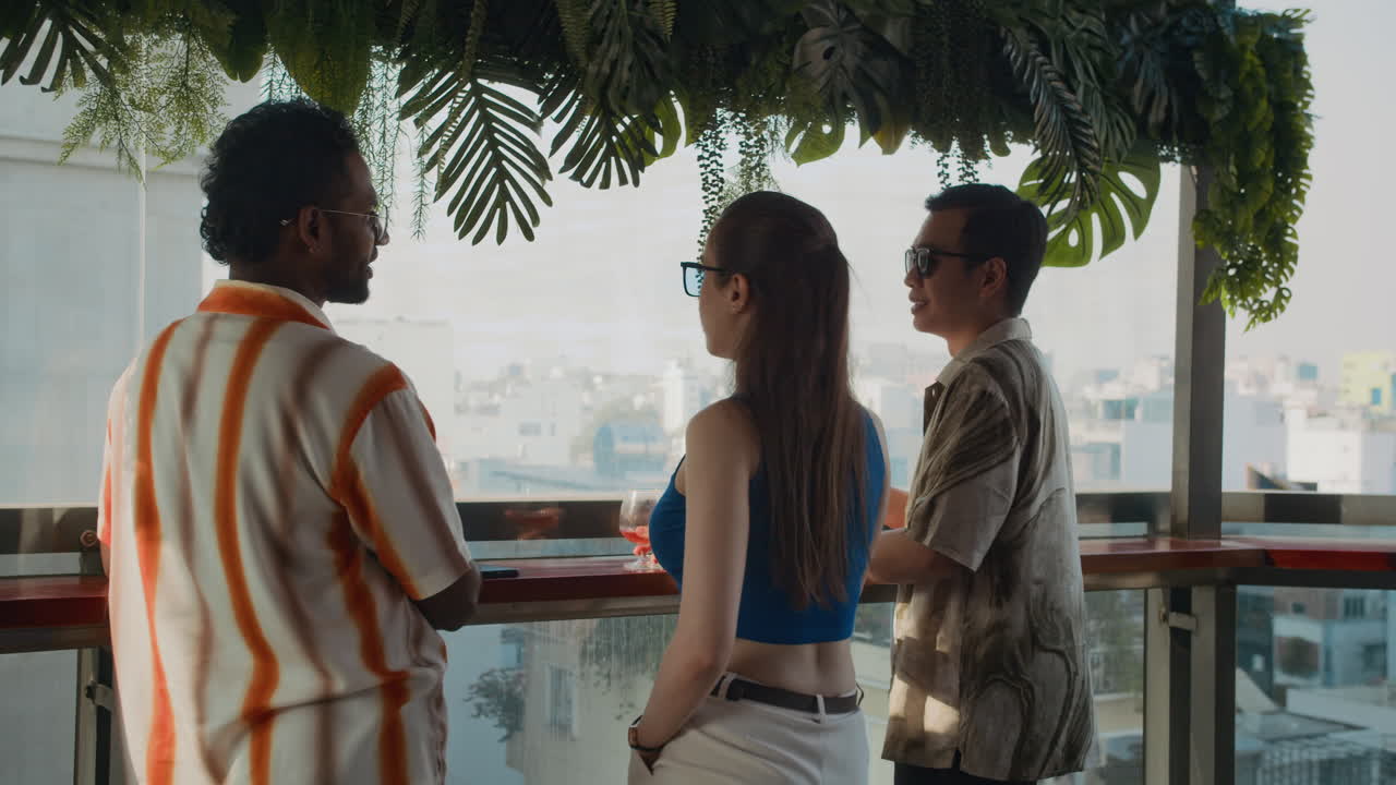 Bi-ethnic People Enjoying City View and Drinking Cocktails at Cafe