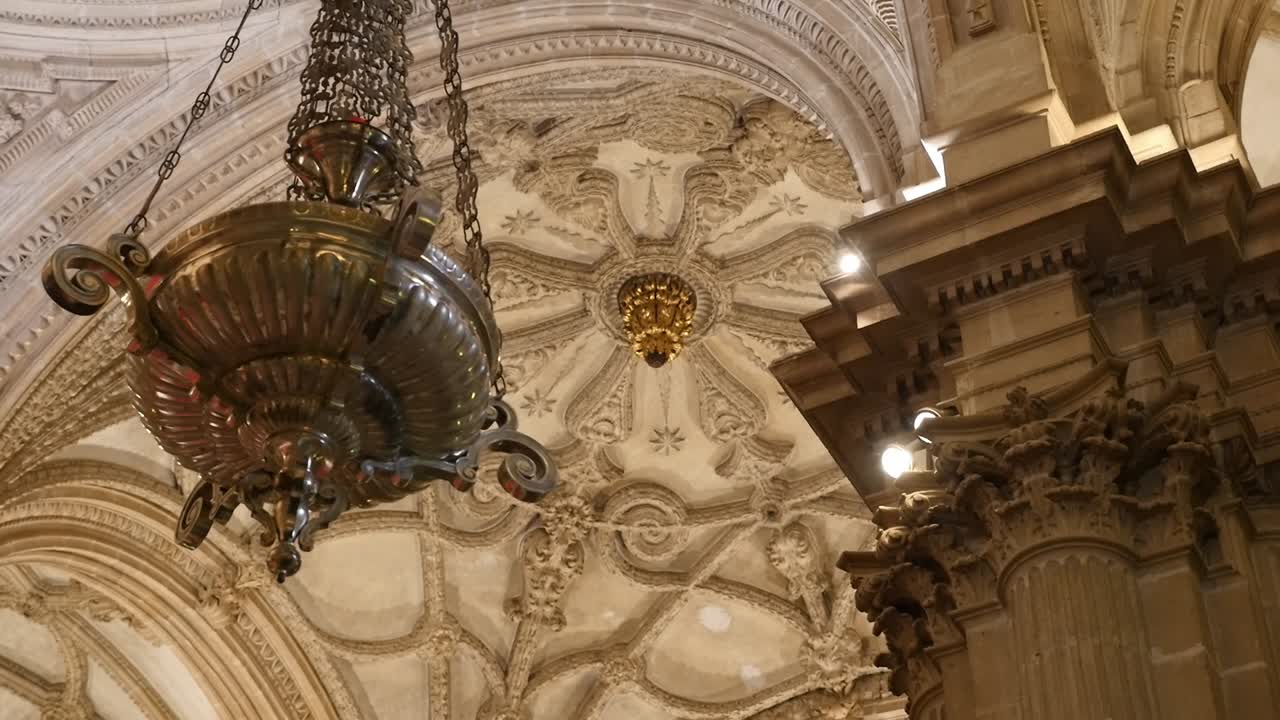 Ornate lamp and carved ceiling of Guadix Cathedral. Renaissance and Baroque architecture in Granada
