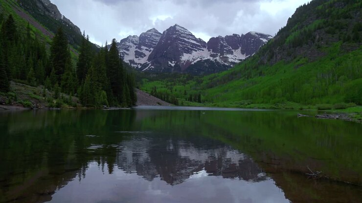 Maroon Bells Wilderness 14ers riflesso sul lago Maroon, paesaggio panoramico Aspen Snowmass nuvoloso e tempestoso primaverile estivo, Elk Mountains Pyramid Peak Colorado Rocky Mountains, il panorama più fotografato statico