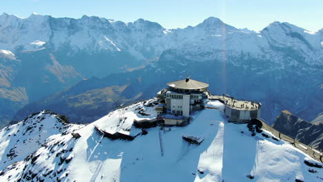 schilthorn piz gloria: fantastic aerial view traveling out over the station and with snow-capped mountains and a spectacular landscape