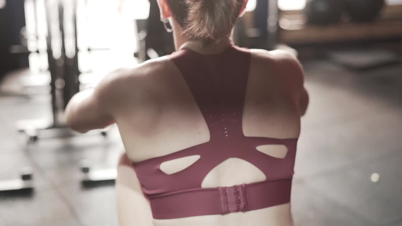 Woman Working Out on Rowing Machine in Gym