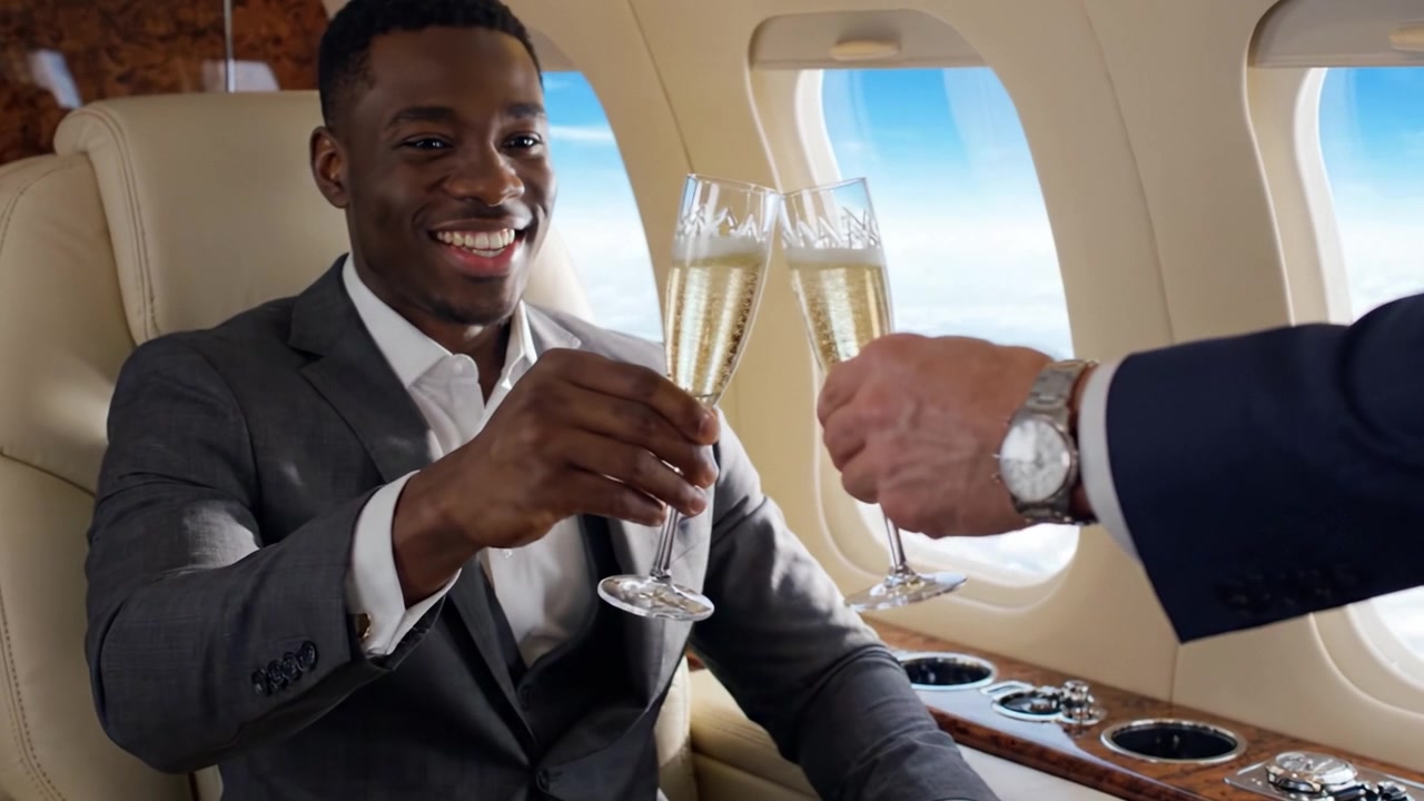Celebrare il successo: un uomo sofisticato si gode un brindisi con champagne in un lussuoso jet privato con viste mozzafiato sul cielo e sulle nuvole