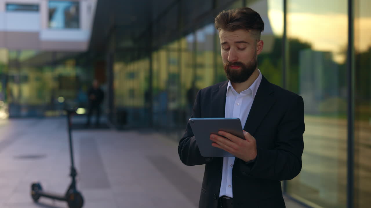 Businessman using a tablet in front of a modern building