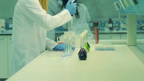 in the lab, procedures for corona virus testing are initiated. light gliding between the purple liquids in the beaker. chemistry liquid measuring device. chemistry. the laboratory.