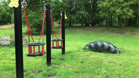 lonely red swings in an empty children playground in eslöv, sweden