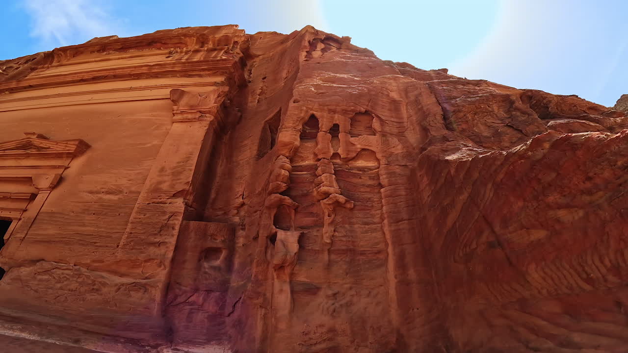 Rock-cut temple in the ref rock formation. Low angle view of The Treasury temple (Al-Khazneh) in Petra, Jordan