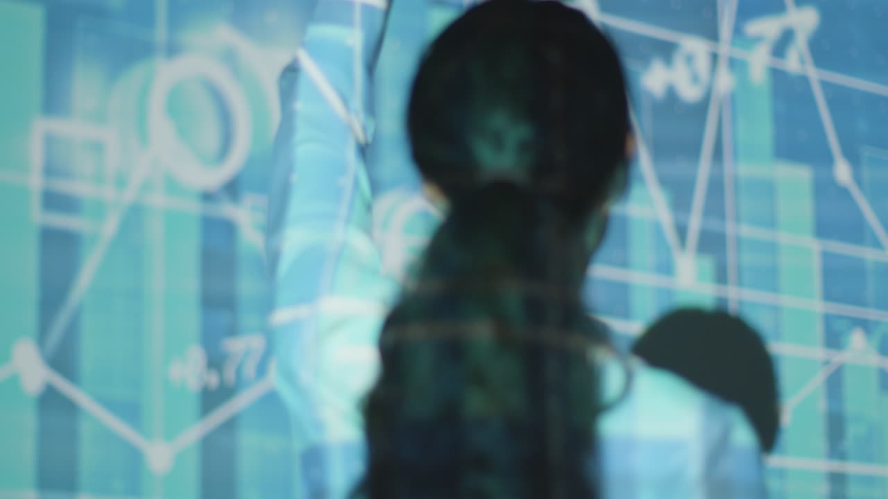그래프와 주식 가격과 함께 금융 데이터를 투영하는 몰입 예술 전시회를 방문하는 여성 9