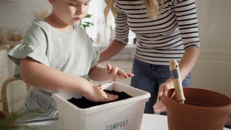 video de una madre y su hija preparando compost.