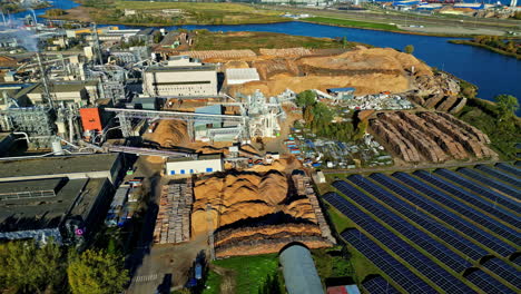 aerial view of a latvian wood factory with logs, woodchips, and solar panels nearby