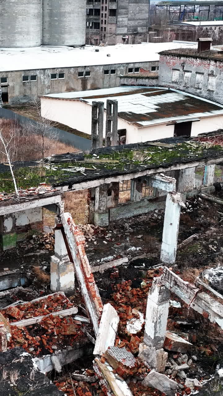Devastated territory with ruins and wrecks at wartime. Aerial perspective on debris left after the bombing. Vertical video