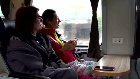 women sit on the train and talk