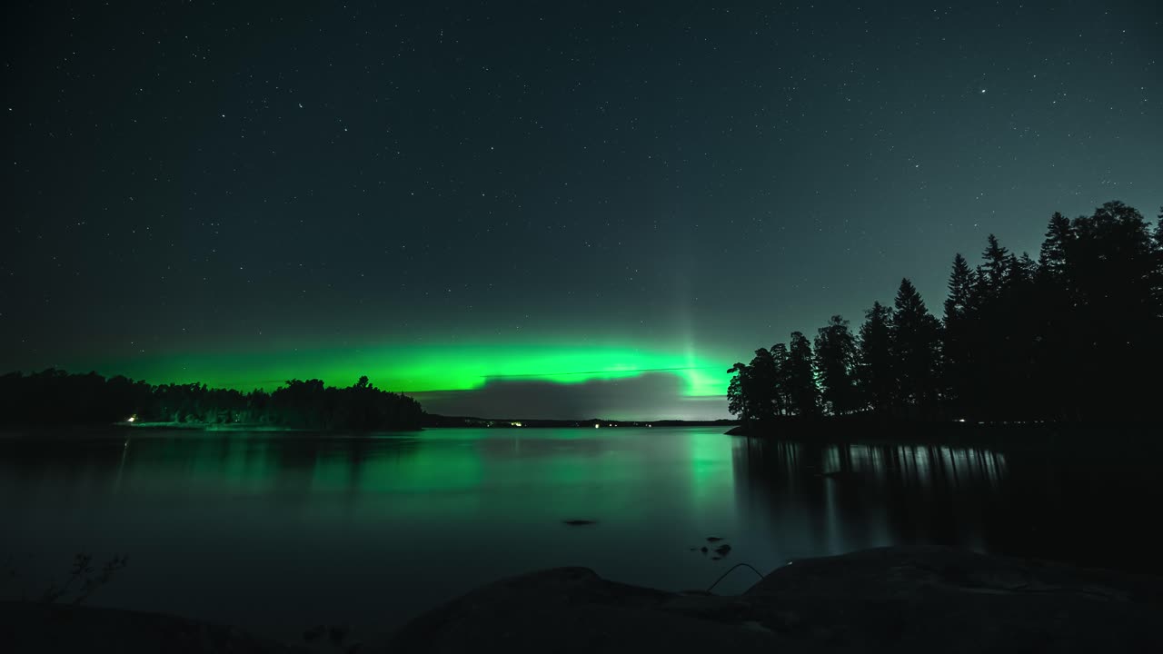 lapso de tiempo de aurora boreal bailando y brillando sobre un lago, caída en finlandia