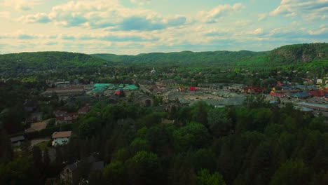 Aerial-Green-Mountains-Surround-Cute-Town-with-Chapel-in-Background