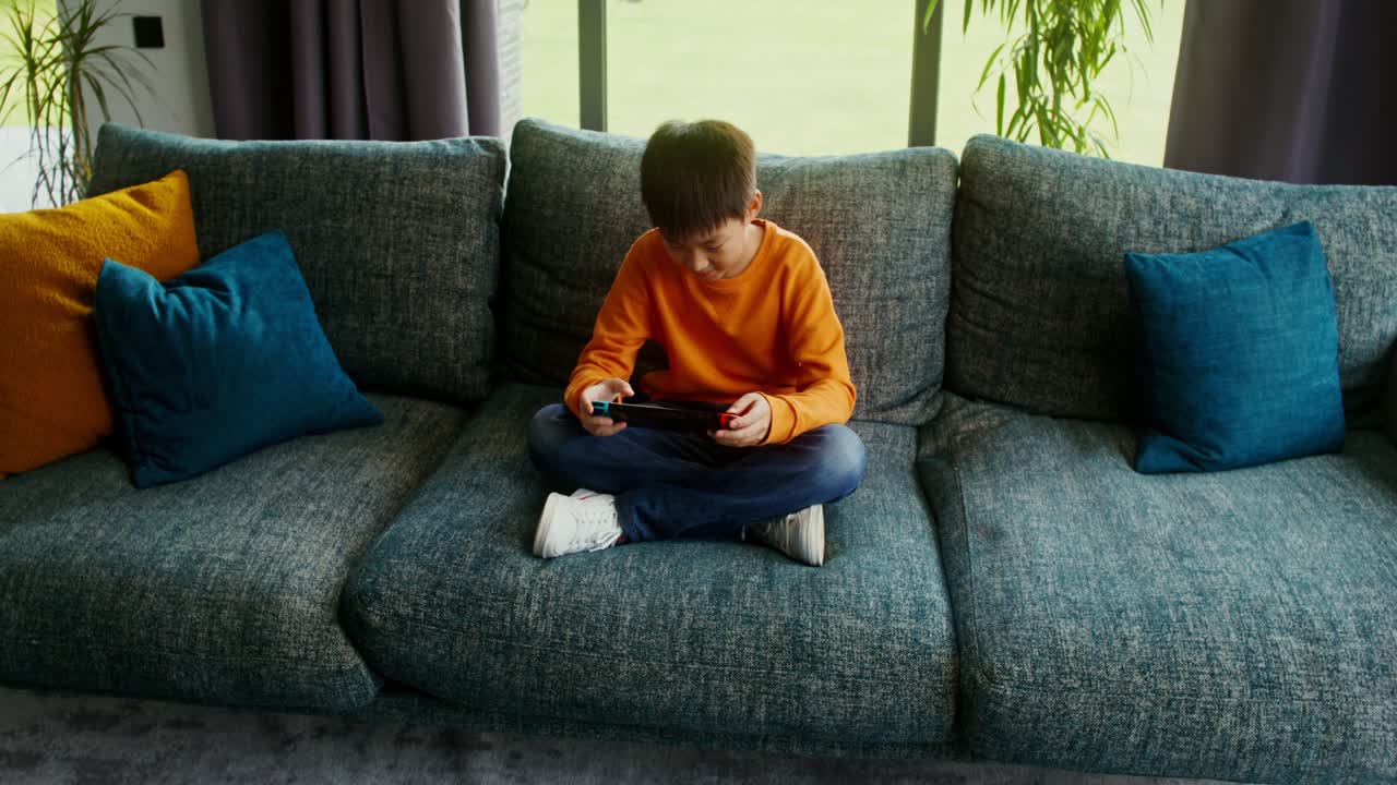 Ragazzo che gioca ai videogiochi sul divano