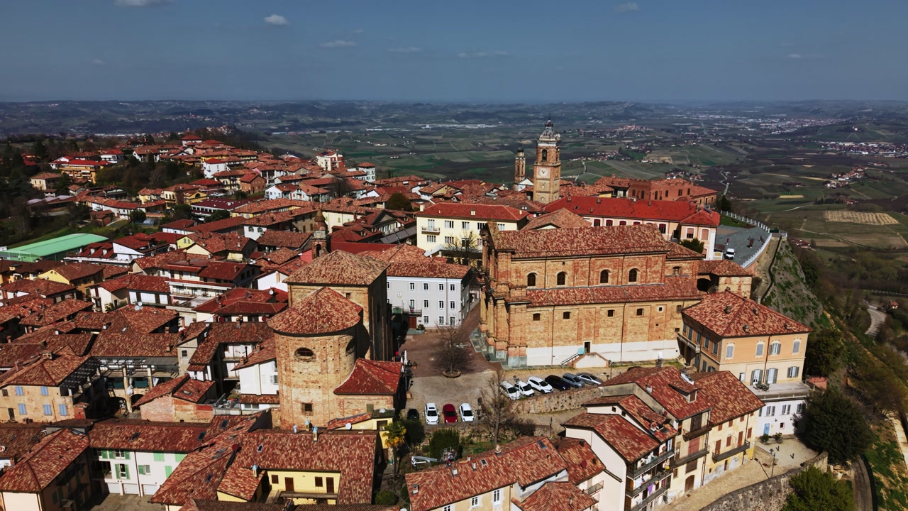 Scenic La Morra village in Langhe wine region with vineyards and historic church, Italy. Aerial orbit
