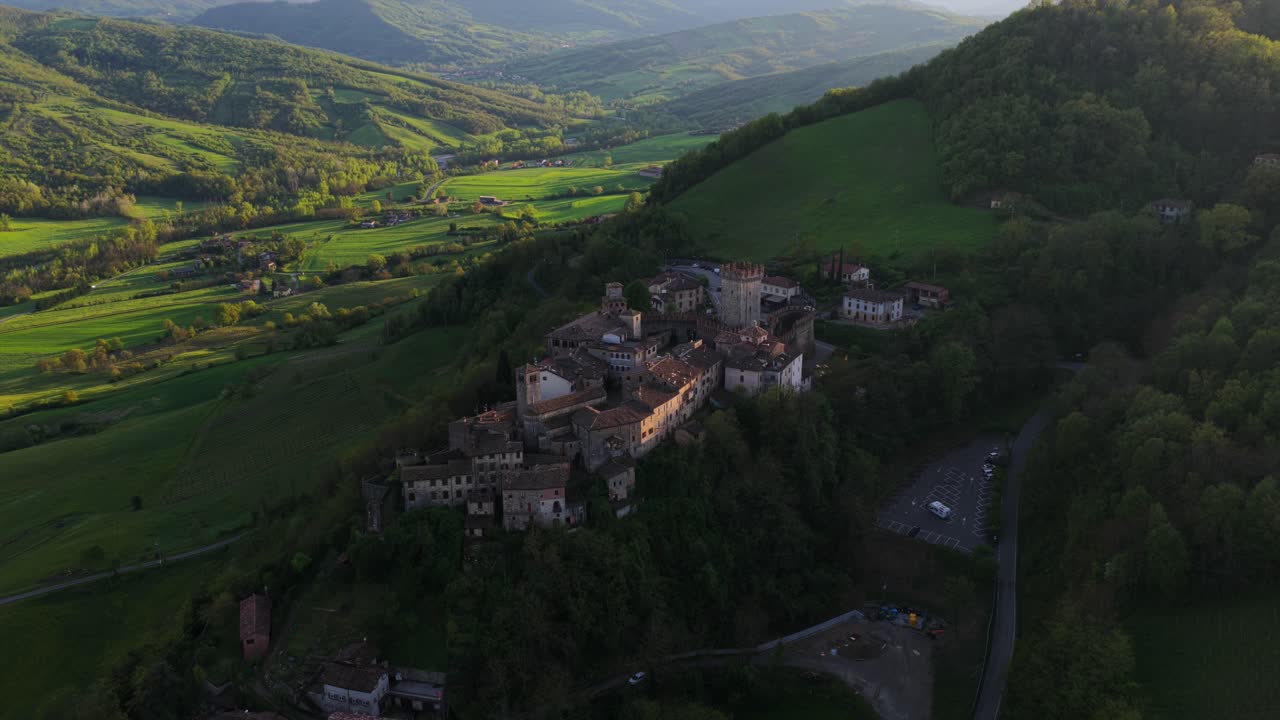 Aerial View Of Vigoleno In Piacenza, Italy - Medieval Village On Green Hillside. pullback tilt-up shot